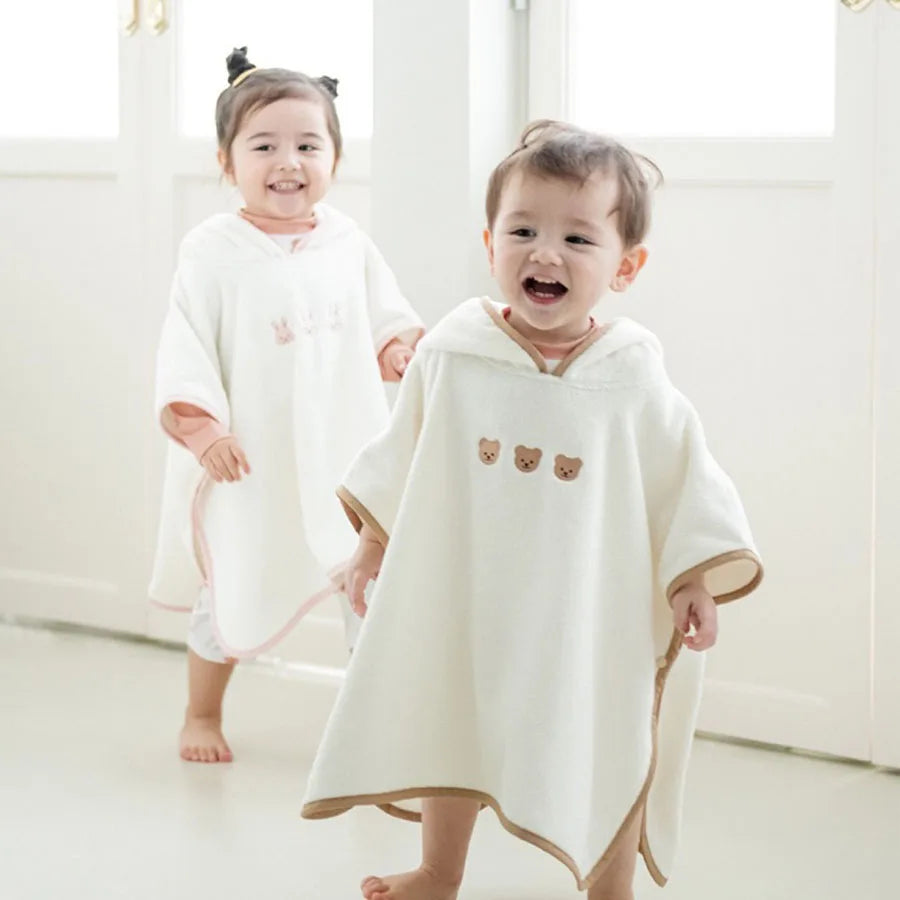 Enfants en poncho de bain écru à capuche, ourlet en pointe et petits ours brodés