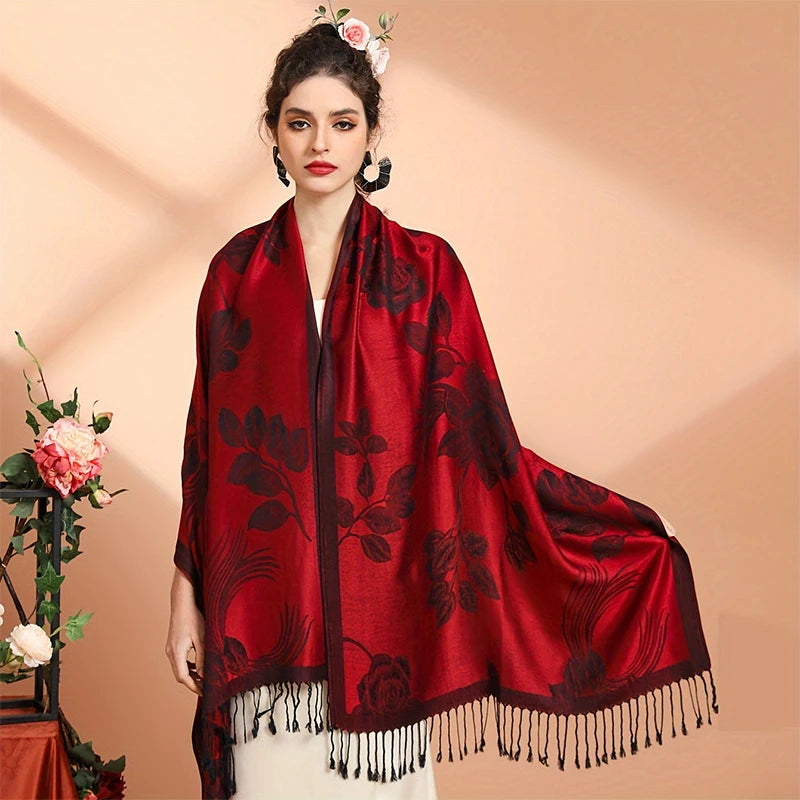 Femme portant le poncho écharpe rouge à roses tissées, drapé sur les épaules et franges noires