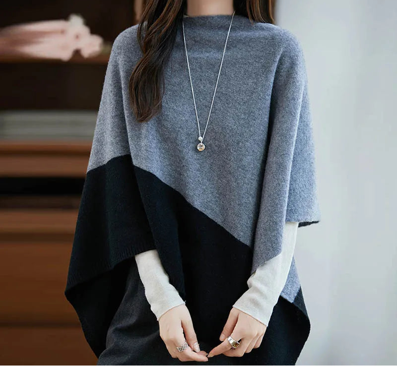 Femme en poncho gris et noir, coupe asymétrique couvrant les bras, mains dégagées
