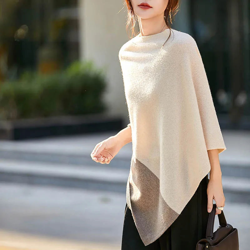 Femme portant le poncho écru et beige, bras tendu, ourlet en pointe et col arrondi