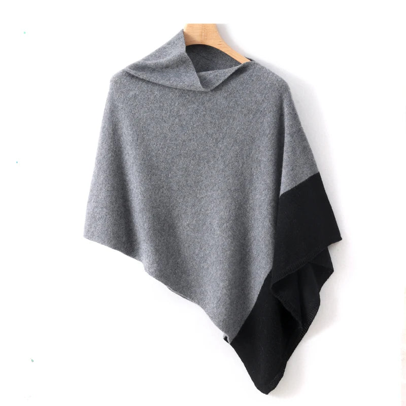 Poncho court gris à panneau noir, encolure bateau et pointe basse, suspendu sur un cintre
