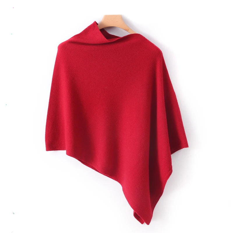 Poncho court rouge vif suspendu, encolure bateau roulée et ourlet oblique très marqué