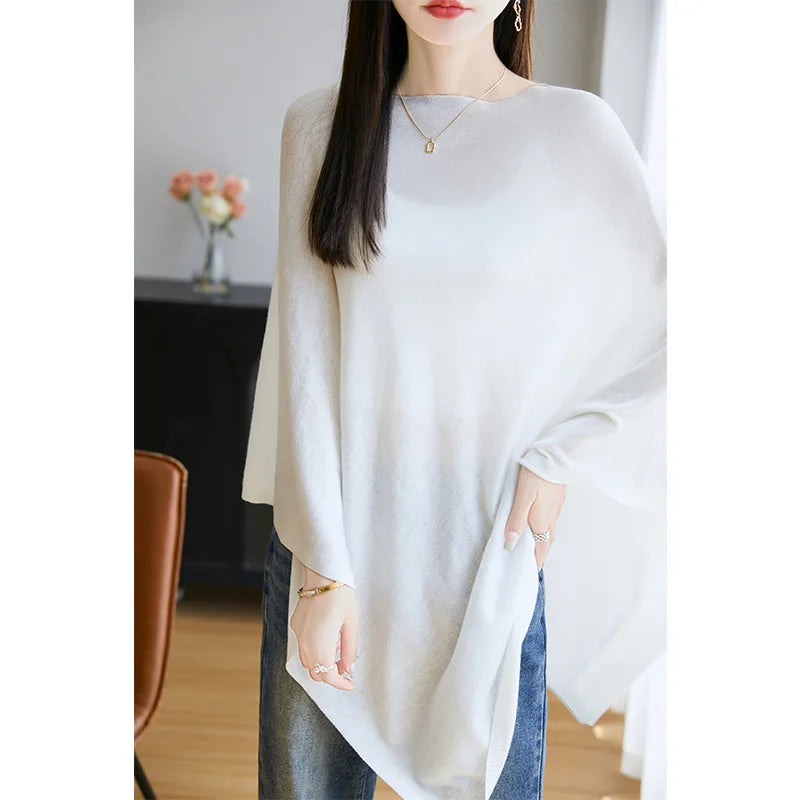 Poncho femme écru en maille fine, tombé asymétrique sur un jean, encolure large