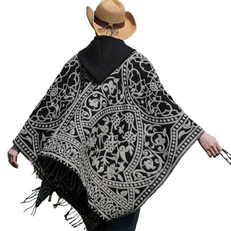 Poncho homme à motifs baroques gris sur noir porté bras écartés, ourlet frangé
