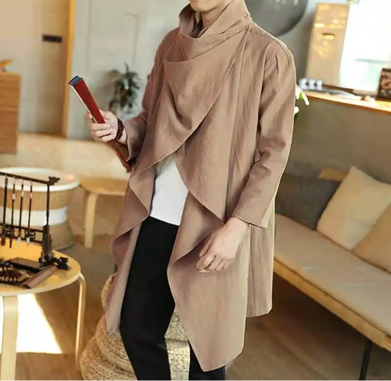 Homme portant le poncho beige à col drapé, ouvert sur un tee-shirt blanc, en intérieur